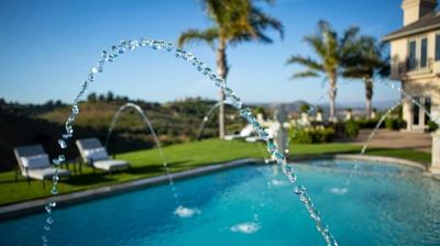 A grandiose aquatic oasis framed by lush greenery and and water features. Photo