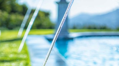 A swimming pool with water features embraced by manicured grass. Photo