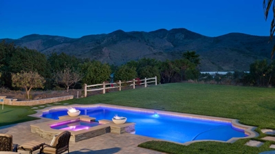 Custom patio and pool area with mountain view at night Photo