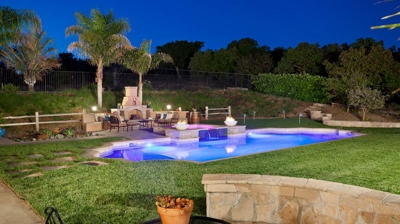 View of illuminated pool at night from seating area Photo