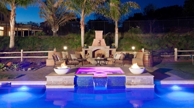 Poolside patio area with custom fireplace and spa Photo
