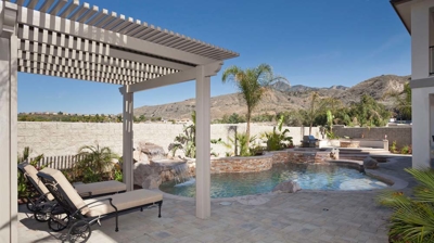Desert pool refuge with palm tree and spa accompanied by a gentle waterfall. Photo