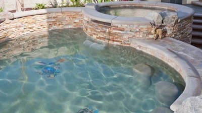 Arid pool escape with palm tree and spa boasting a picturesque waterfall. Photo