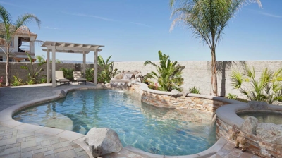 Desert pool oasis with palm tree and spa with waterfall. Photo