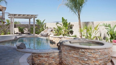 Desert pool haven adorned with palm tree and spa with cascading waterfall. Photo