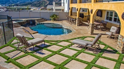 Oasis-inspired pool and spa surrounded by desert pavement and grass, providing valley views. Photo