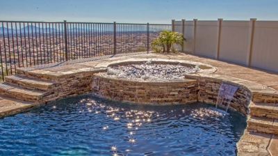 Serene pool and spa integrated into desert pavement, offering valley vistas. Photo