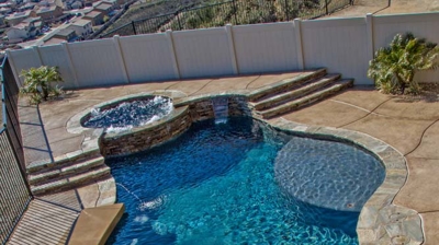 Enchanting pool and spa harmonized with desert pavement and grass, offering valley perspective. Photo