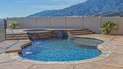 Idyllic pool and spa adorned by desert pavement and grass, with valley overlook. Photo