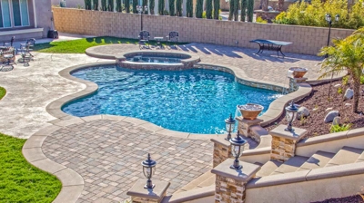 Outdoor serpentine pool with a relaxation area and lush lawn. Photo
