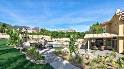 A pool and spa, nestled among desert rocks and swaying palms. Photo