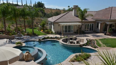 Luxuriant garden retreat with a pool, spa, and integrated fire pit. Photo