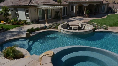 Lush backyard haven boasting a pool, spa, and fire pit seamlessly integrated. Photo