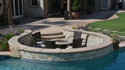 Backyard paradise boasting a pool, spa, and fire pit, enveloped in lush foliage. Photo