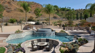 Garden escape with a pool, spa, and fire pit nestled amidst verdant surroundings. Photo