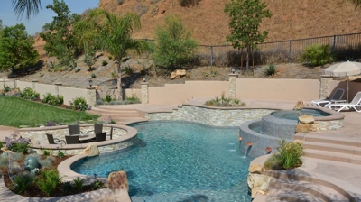 Retreat showcasing a pool, spa, and built-in fire pit in the lush backyard. Photo