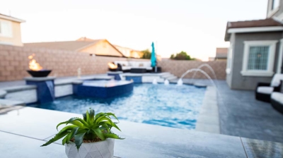 Luxurious backyard featuring a spacious pool with vibrant blue tiles and a relaxing spa. Photo