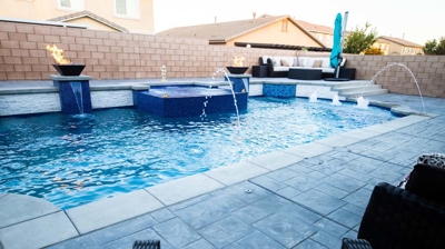 Backyard oasis complete with a sizable pool adorned in vivid blue tiles and a soothing spa. Photo