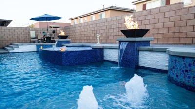 A stunning backyard retreat showcasing a large pool with striking blue tiles and an inviting spa. Photo