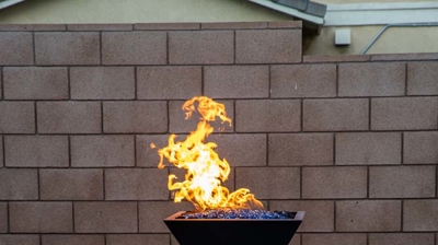 Serene backyard haven with a spacious pool complemented by vivid blue tiles and fire features. Photo