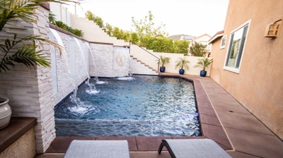 Poolside retreat featuring in-ground pool, raised spa, and flowing waterfall. Photo