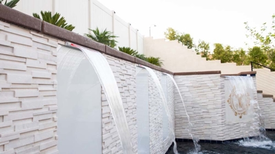 Aquatic haven boasting in-ground pool, raised spa, and tranquil waterfall. Photo