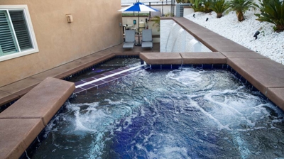 Poolside escape with sunken pool, raised spa, and picturesque waterfall. Photo