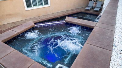 Waterside retreat showcasing in-ground pool, raised spa, and enchanting waterfall. Photo