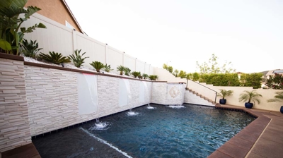 Aquatic sanctuary with sunken pool, elevated spa, and cascading waterfall. Photo