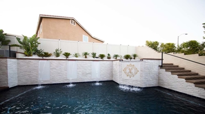 Waterside sanctuary with in-ground pool, raised spa, and cascading waterfall. Photo