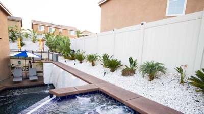 Waterside oasis with sunken pool, elevated spa, and picturesque waterfall. Photo
