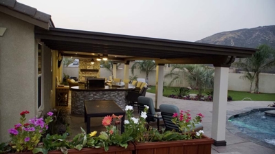 Outdoor dining and bbq area next to a pool. Photo