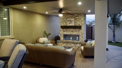 Outdoor terrace featuring conversational seating and a fireplace. Photo