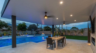 Stylish backyard oasis offers in-ground pool, spa, and conversation zone for gatherings. Photo