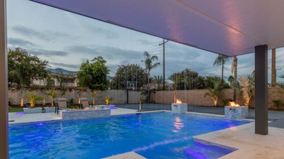 Chic backyard setup showcases modern pool, spa, and conversation zone. Photo