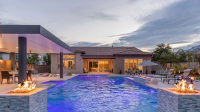 Trendy outdoor retreat boasts sleek pool and spa with fire features. Photo