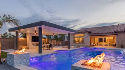 Chic backyard setup showcases modern pool, spa, and fire elements. Photo