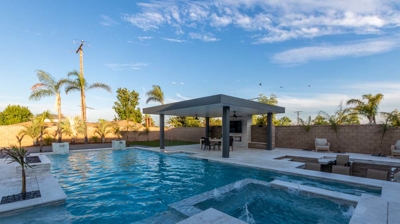 Sleek outdoor space features modern pool spa BBQ lounge pit. Photo