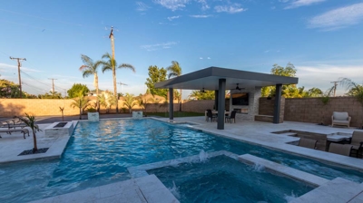 Stylish backyard oasis: in-ground pool spa conversation zone for BBQ gatherings. Photo