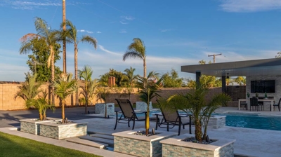 Contemporary backyard design features in-ground pool and spa conversation area. Photo