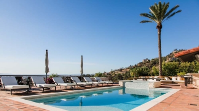 Majestic Spanish estate with a picturesque pool adorned with graceful water features. Photo