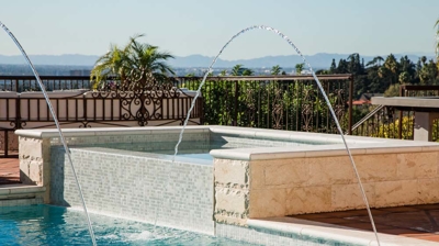 Spanish-inspired dwelling showcasing a luxurious pool area with intricate water features. Photo