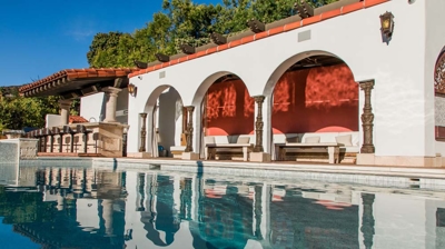 Elegant Spanish-style residence boasting a luxurious pool and water features. Photo