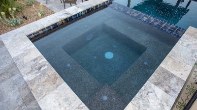 Calm hot tub with waterfall fixture on one end. Photo