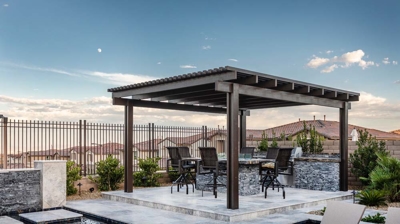Luxurious outdoor space with a pool, hot tub, and pergola-covered dining area. Photo