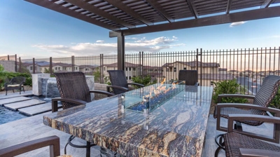 Covered outdoor dining area next to a beautiful, modern pool. Photo