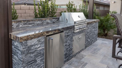 Stylish outdoor kitchen with refrigerator and grill. Photo