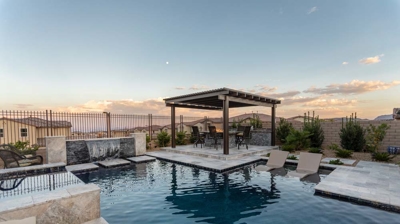 Spacious pool area with a hot tub, pergola-covered dining space, and comfortable seating. Photo