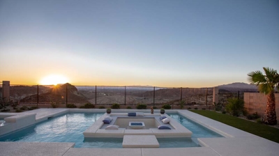Patio with sunken seating area in pool and view of the desert Photo