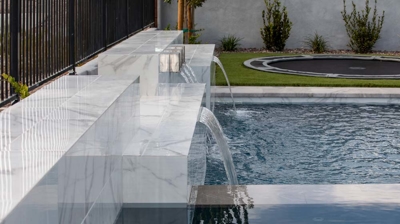 Custom stone pool wall with cascades Photo